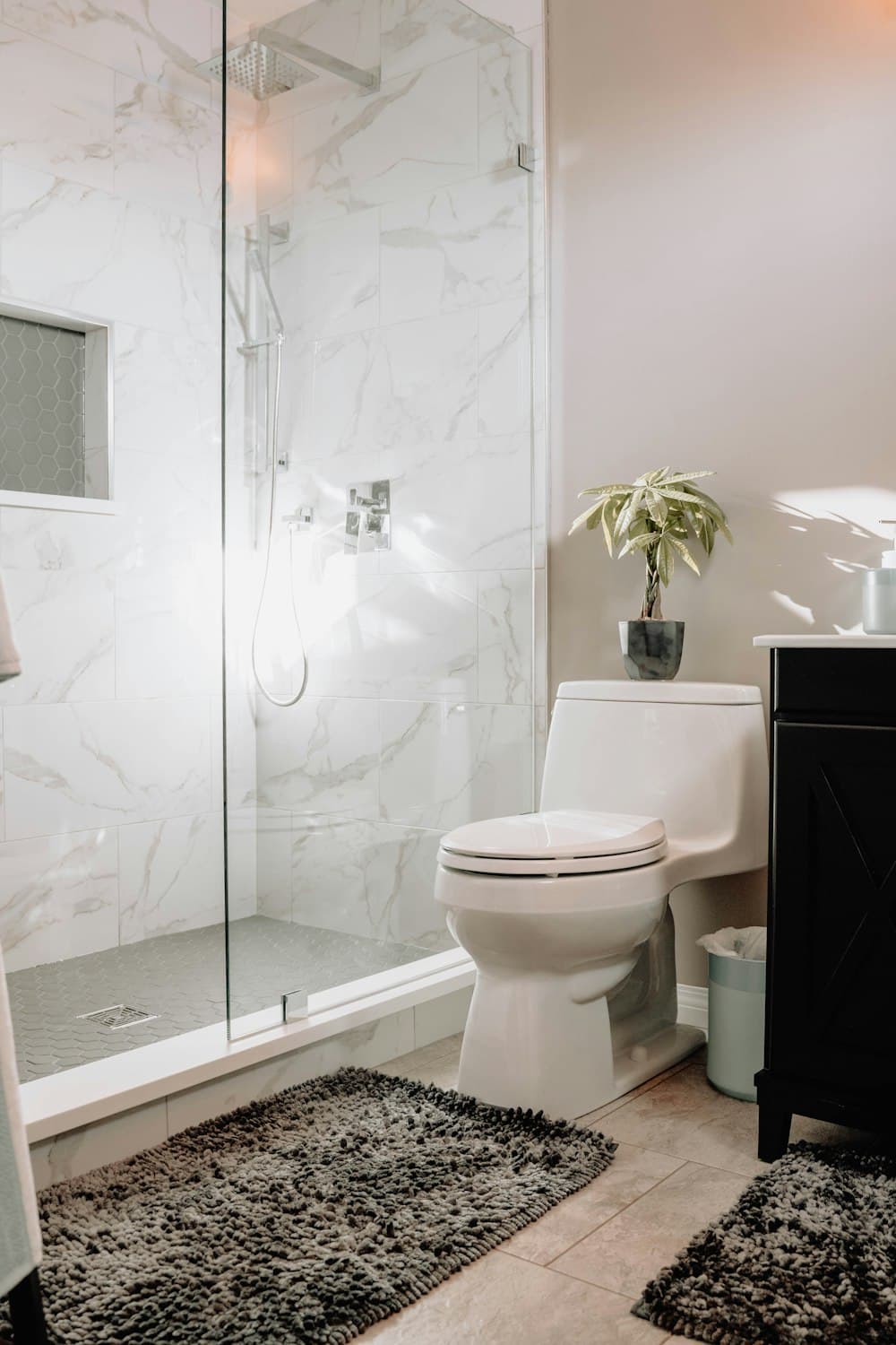 A bright marble bathroom with a glass walk-in shower